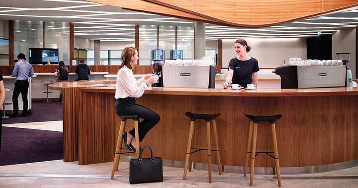 Lady speaking to friendly staff at the Virgin Australia Lounge in Brisbane Domestic Airport