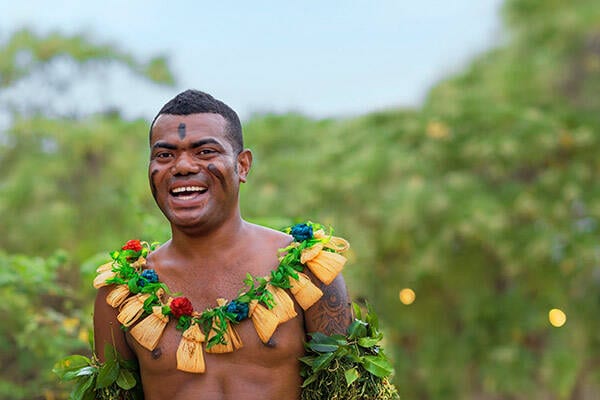 Fijian man smiling and wearing traditional dress