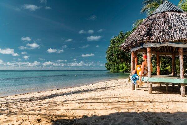 Woman sitting in villa overlooking beach in Samoa