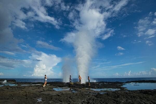 People exploring rockpools on the coastline in Samoa