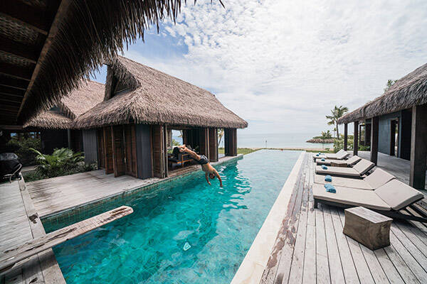 Man diving into pool at the Six Senses Resort pool in Fiji