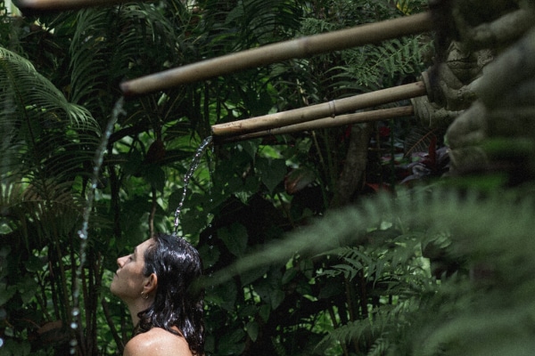 Woman enjoying outdoor shower at Views at Bali Silent Retreat
