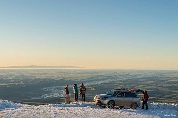 Four people standing on Mount Hutt with a four wheel drive