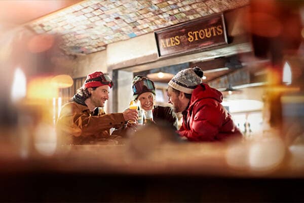 Three friends enjoying a drink in a ski bar
