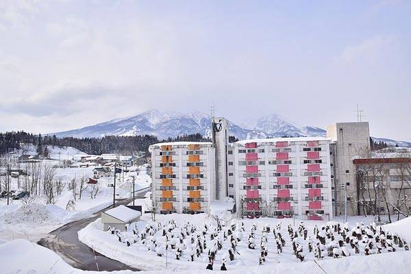Hotel Olympic Inn Myoko Kogen with snow capped mountains in the background