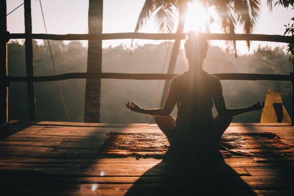 woman meditating on brown wooden dock in Ubud