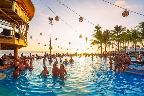 Party goers in the pool during sunset at Finns beach Club, Canggu