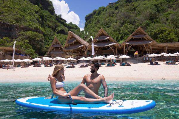  A couple stand up paddle boarding at Sundays Beach Club