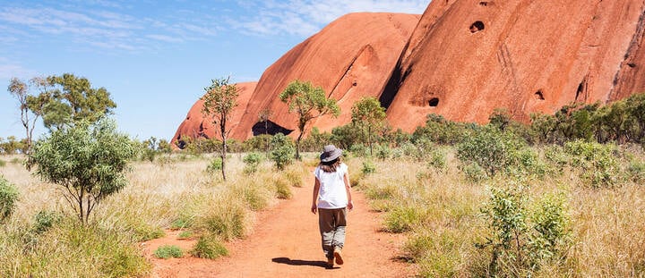 Woman walking in the red center, Uluru,Northern Territory
