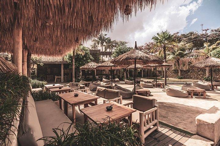 Palm trees and seated area at Mano Beach House, Bali
