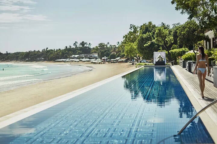 View of swimming pool and trees at Sundara Beach Club, Bali