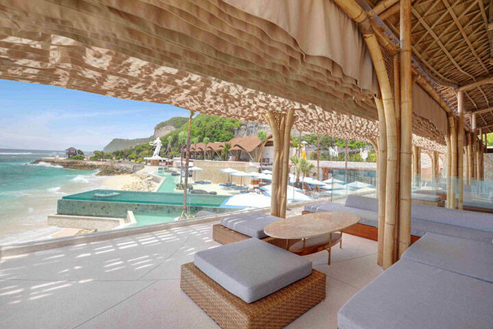 Cabanas overlooking beach waves at Tropical Temptation Beach Club, Bali