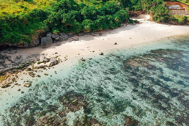 Aerial view of turquoise water, rocks and ocean scenery at Gunung Payung Secret Beach, Bali, Indonesia