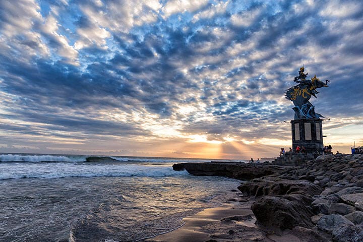 Sunset behind the sculpture of Gajah Mina on Pererenan Beach in Canggu, Bali