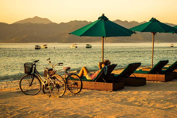 Bicycles standing on the sand beach during sunrise with blue ocean background, Gili Trawangan, Bali, Lombok, Indonesia