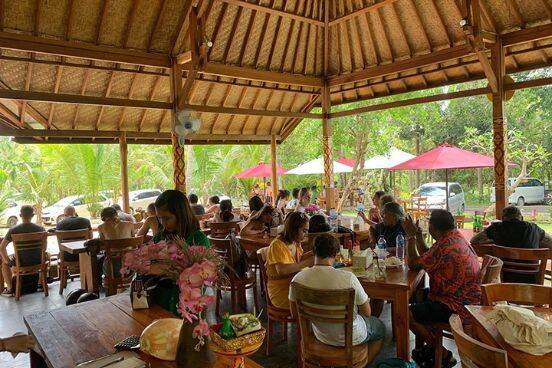 Diners sitting at tables enjoying lunch under covered patio at Resto Duma Nusa Penida, Bali