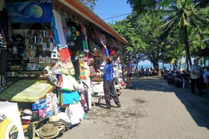 Vendor setting up shop on road at Kuta Art Market, Bali