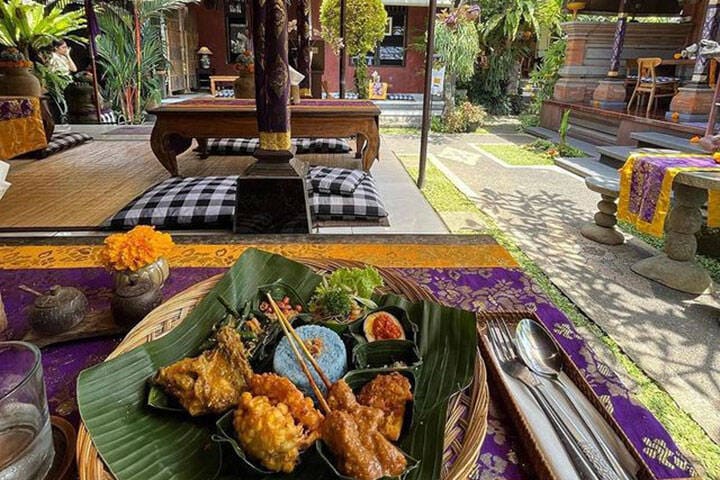 A plate of Balinese food, including skewers and rice, at Sun Sun Warung in Ubud, Bali