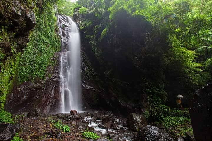 Water stream gushing down hitting rocks at Yeh Mampeh Waterfall, Bali