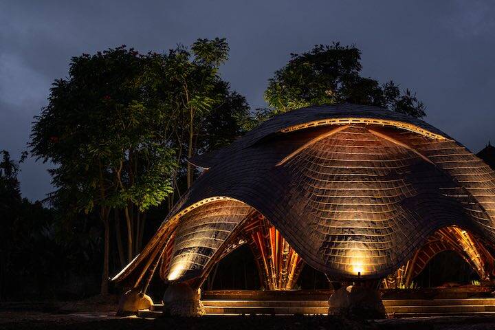 External view of outdoor studio illuminated with lights at night time at Alchemy Yoga & Meditation Center Ubud, Bali