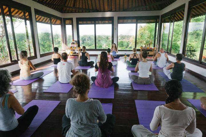 Women sitting down facing instructor at Intuitive Flow Yoga Studio Ubud, Bali