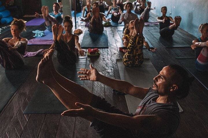 Instructor showing students V sit position at Yoga 108 Bali Seminyak, Bali