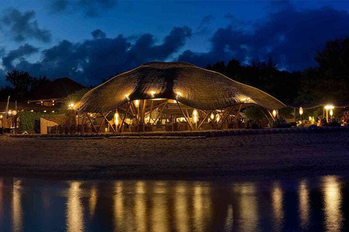 Night time lights illuminate restaurant balcony overlooking water at Pearl Beach Lounge  