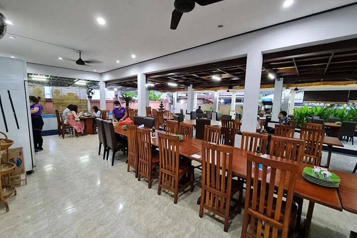 Indoor dining area with chairs and tables along middle at Warung Ibu Rini, Lombok