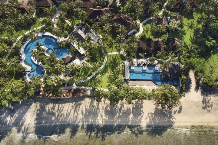 Swimming pool area surrounded by cabanas at The Oberoi, North Lombok