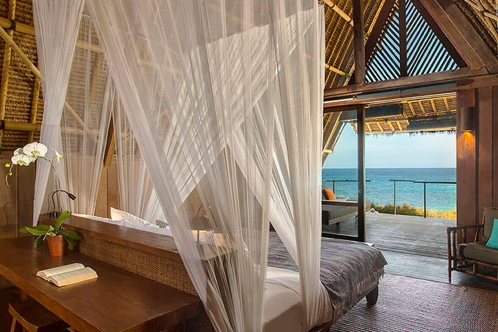 Master bedroom suite facing water view from outside balcony at Jeeva Beloam Beach Camp East Lombok, 