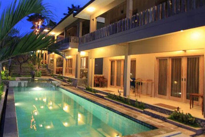 Pool light up at night time in villa area at Rudy Trekkers Hideout Hostel, North Lombok