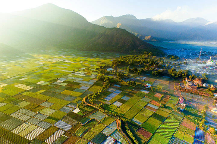 Foggy morning view of beautiful patchwork fields and Sebulan villages., with mountains in the background