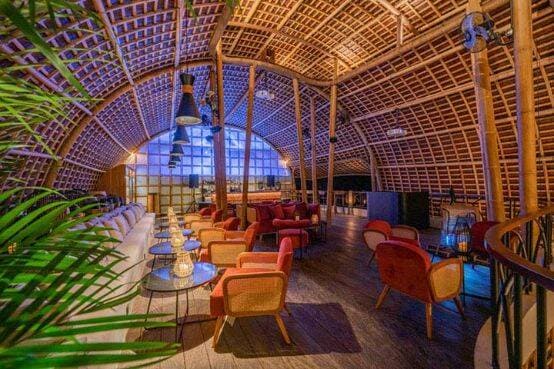 Indoor dining area with cane archway over tables and chairs at Akar Restaurant in Ubud, Bali