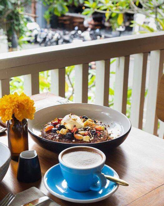 Breakfast pancakes with cup of coffee on dining table at Watercress cafe in Ubud, Bali