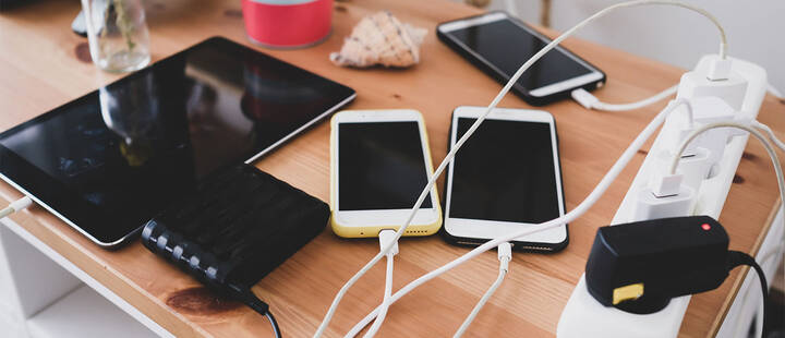 Charged mobile phones and tablets, plugged into a powerboard