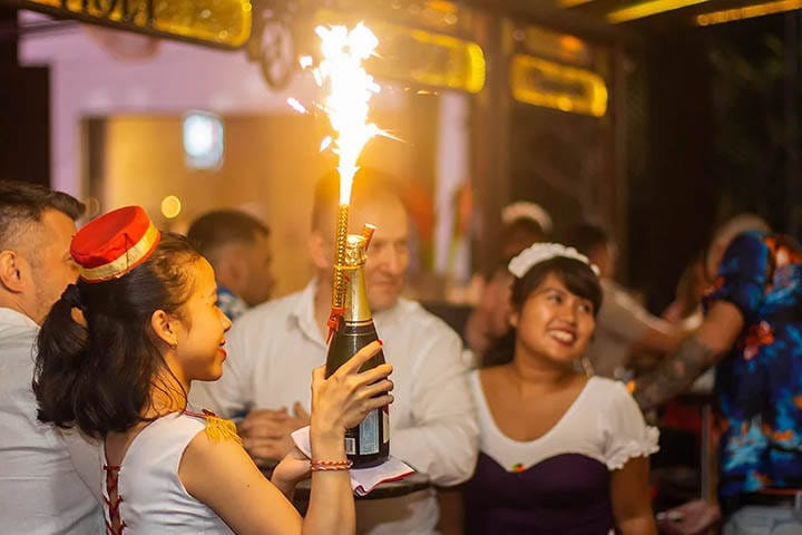 Patrons enjoying food and drink under lit up gazebo bar at Red Carpet Champagne Bar Seminyak, Bali