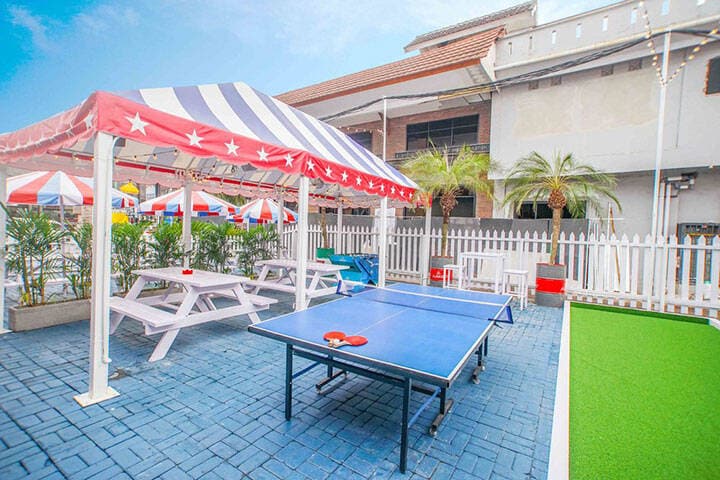 Outdoor dining tables underneath gazebo next to ping pong tables at SHOOTERS Seminyak, Bali