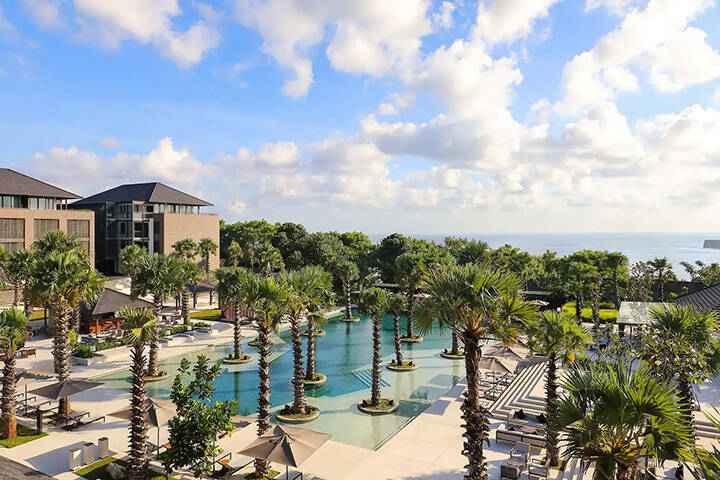 Palm trees surround pool area at Radisson Blu Resort Uluwatu, Bali