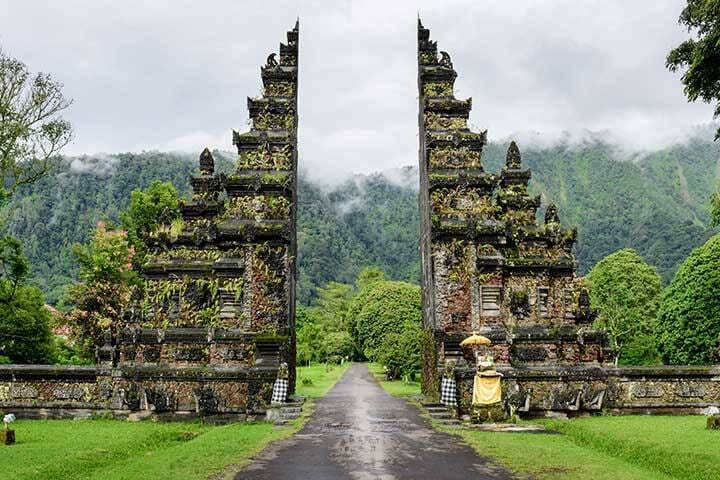 Candi Bentar is a classical Javanese and Balinese gateway entrance, Bali, Indonesia. After the rain, the mountains are misted.
