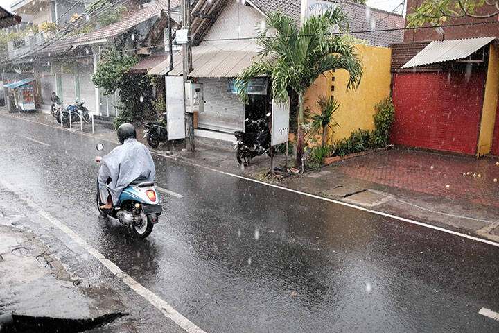 Motor Cyclist in a Street in Rainy Seminyak, Bali