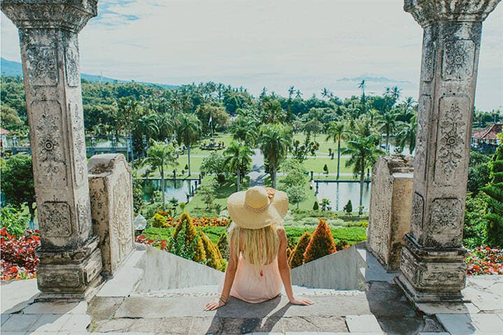 Women in hat and sun dress at Taman Ujung water palace, Bali