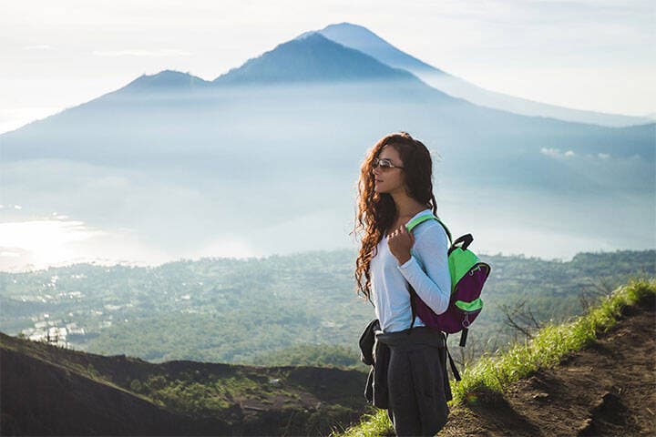 Beautiful woman at the top of Mount Batur after a sunrise hike