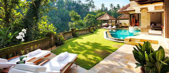 Sun loungers, garden and pool at a private villa at Viceroy Resort, Ubud, Bali