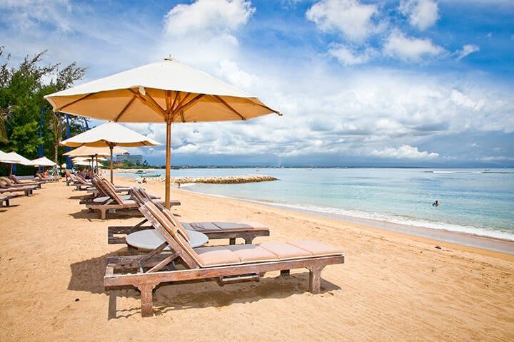 Beach umbrellas and sun loungers on Sanur Beach, Bali