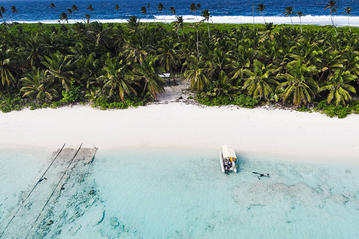 White shores and clear blue water at Direction Island