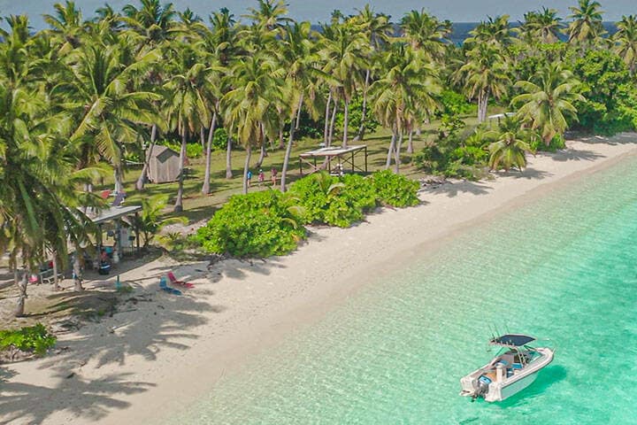 Clear blue water, white sand and palm trees at Direction Island, Cocos Keeling Islands