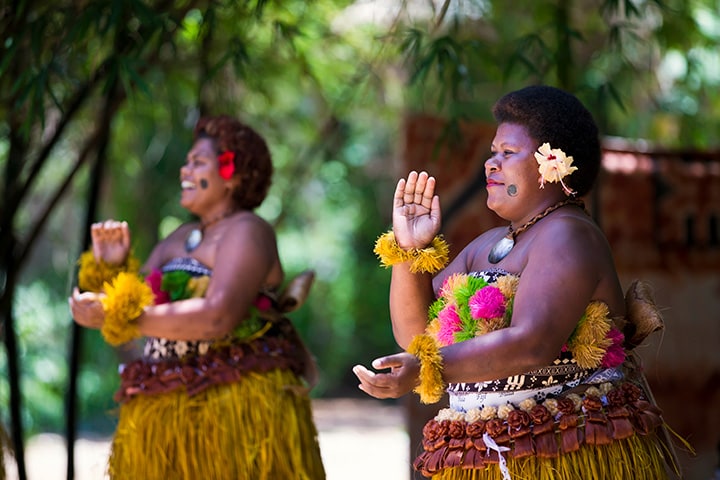 Fijian women smiling and wearing traditional dress