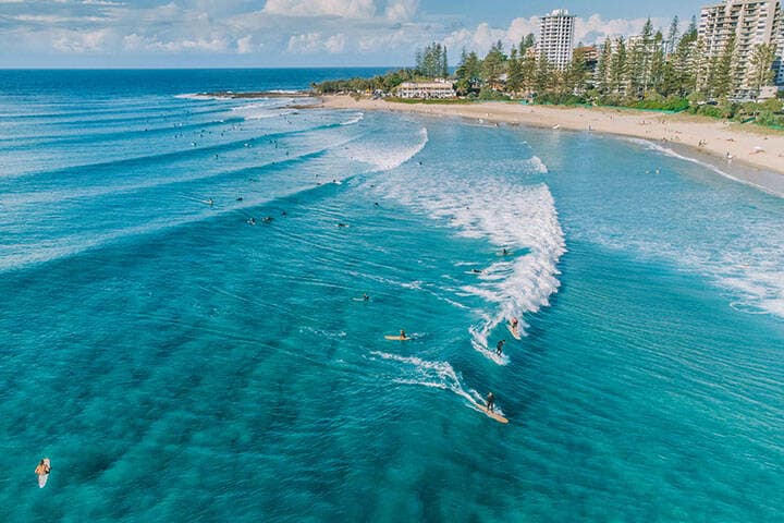An aerial view of surfers and swimmers at Rainbow Bay, Gold Coast, Australia