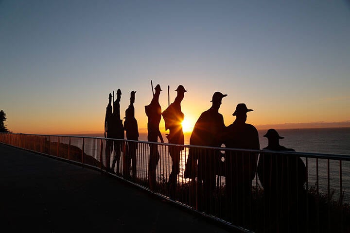 Sun rising over steel silhouettes of soldiers on Newcastle (ANZAC) Memorial Walk, Newcastle