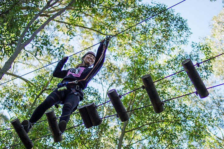 Women crossing over an obstacle at the Treetop Adventure Park in Newcastle. 